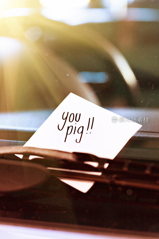 “你猪! !夹在挡风玻璃刮水器下的一张匿名纸条写道